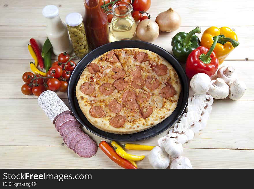 A couple of delicious pizzas, with raw tomatoes, green peppers and salami. A couple of delicious pizzas, with raw tomatoes, green peppers and salami