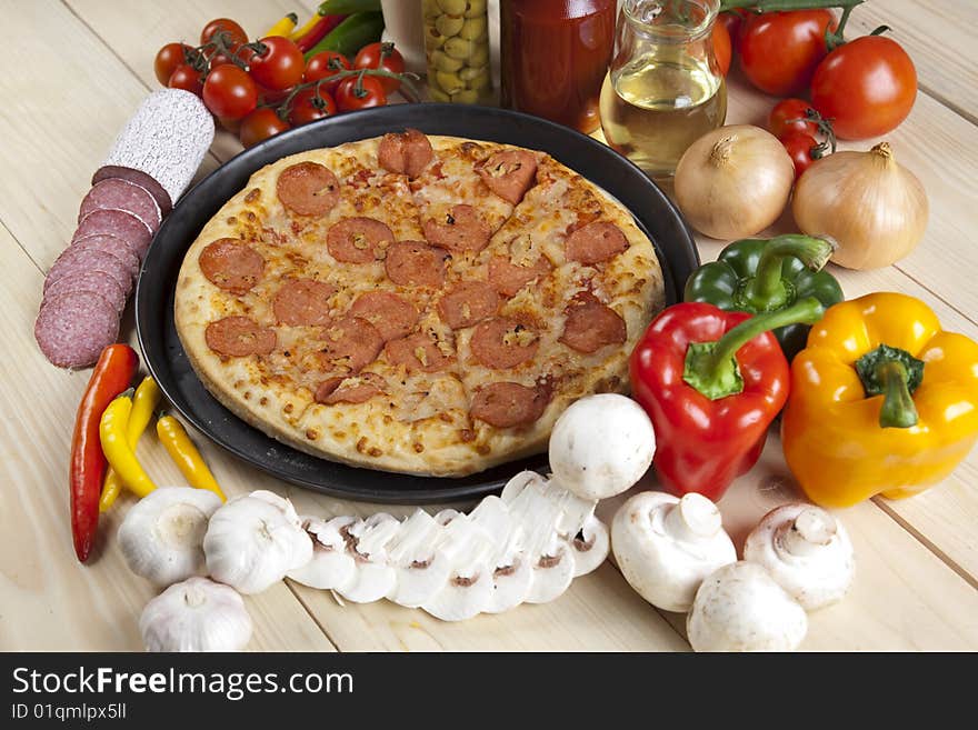 A couple of delicious pizzas, with raw tomatoes, green peppers and salami. A couple of delicious pizzas, with raw tomatoes, green peppers and salami