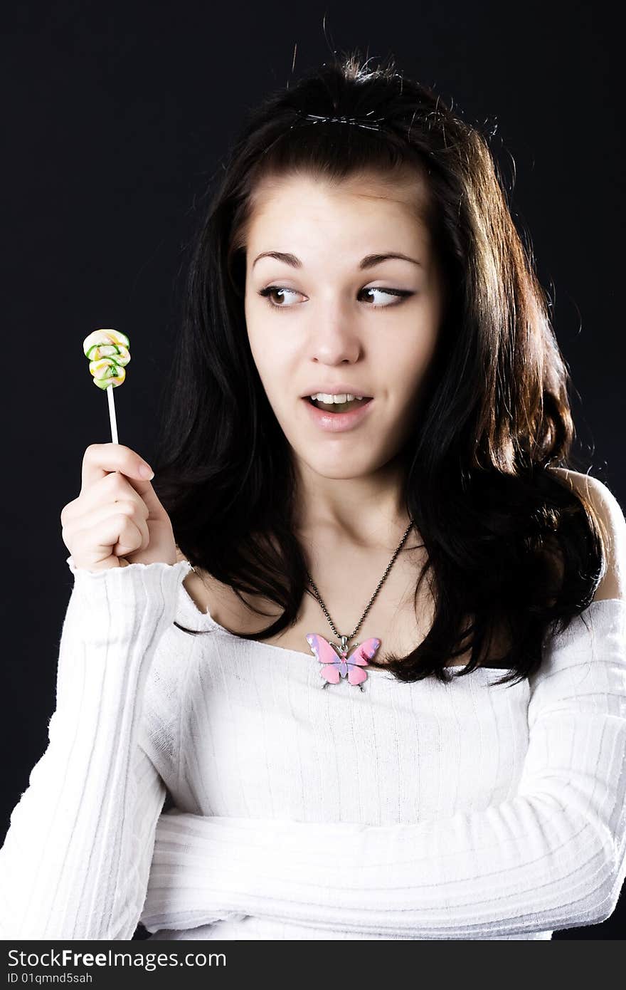 Pretty woman with candy showing surprise