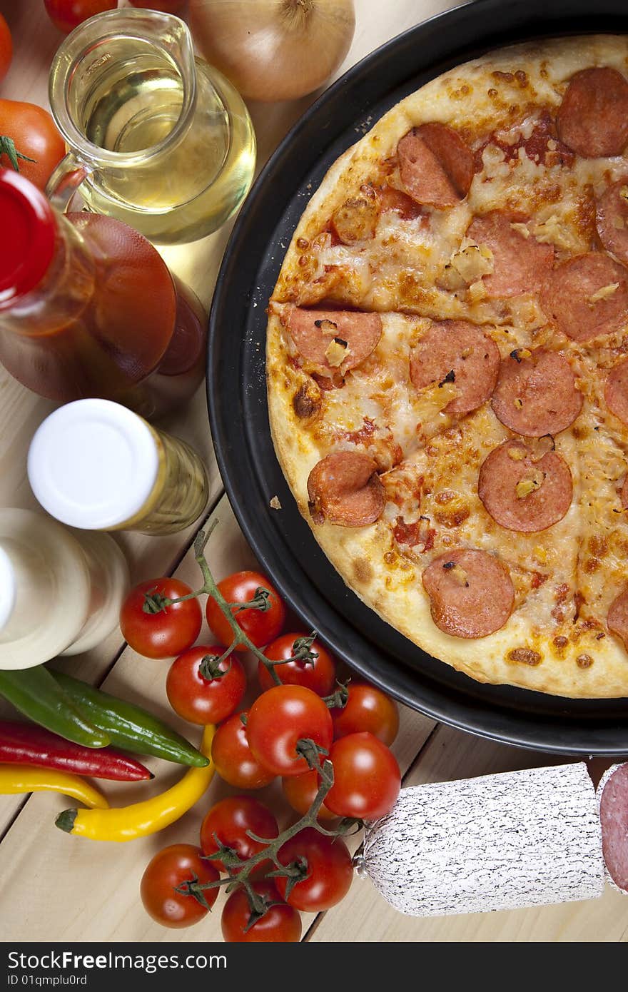 A couple of delicious pizzas, with raw tomatoes, green peppers and salami. A couple of delicious pizzas, with raw tomatoes, green peppers and salami