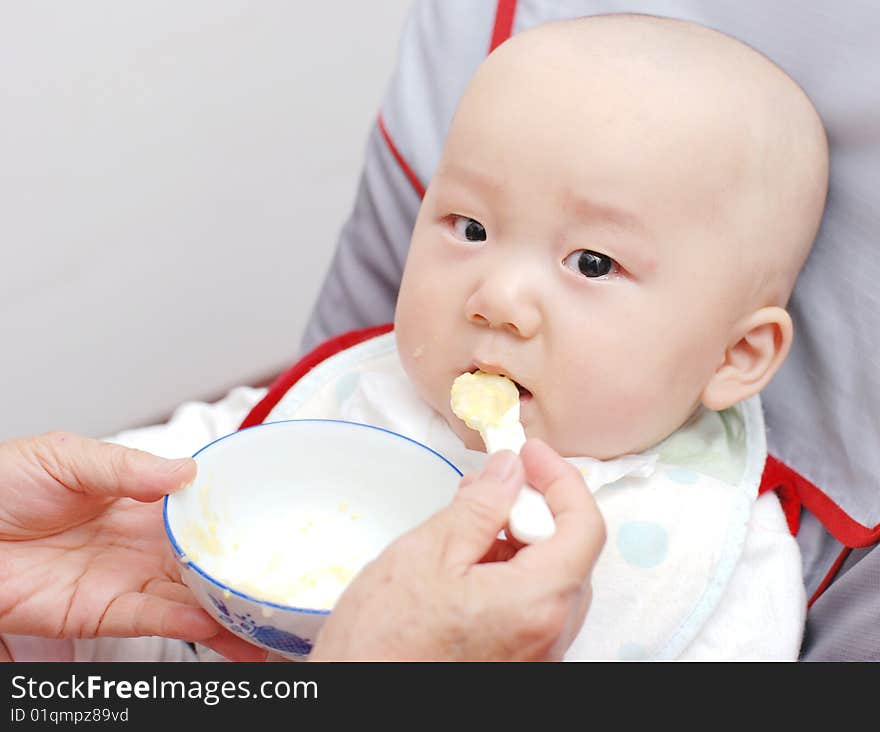 Baby with a spoon in a mouth. Baby with a spoon in a mouth