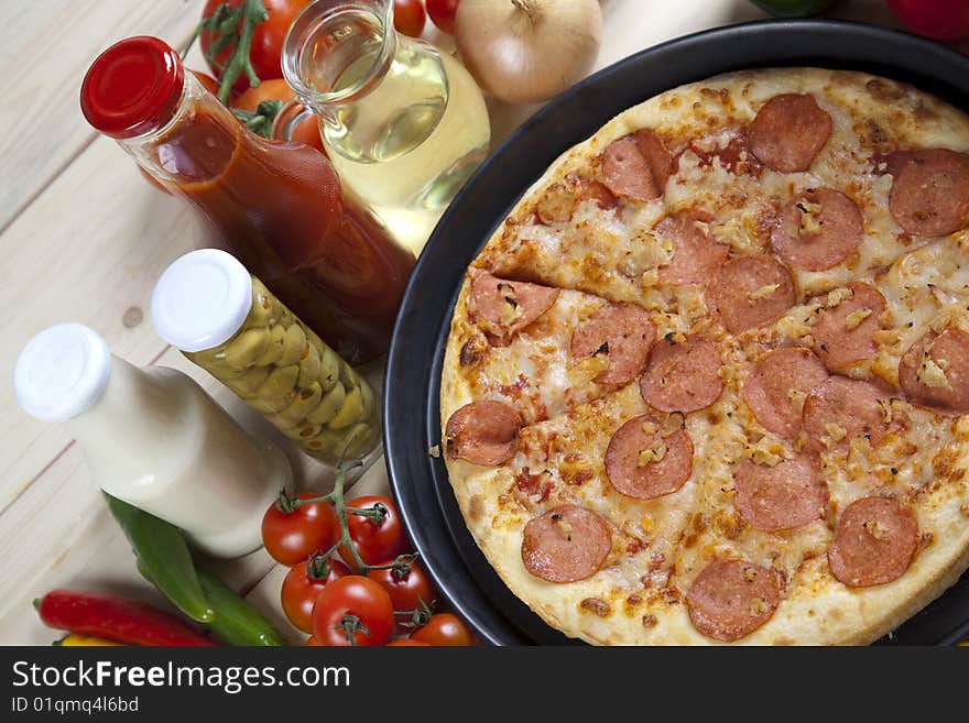 A couple of delicious pizzas, with raw tomatoes, green peppers and salami. A couple of delicious pizzas, with raw tomatoes, green peppers and salami