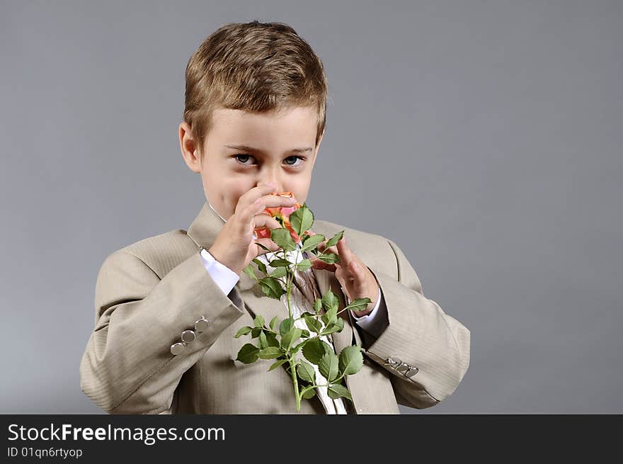 Little boy smelling orange flower and expressing his love