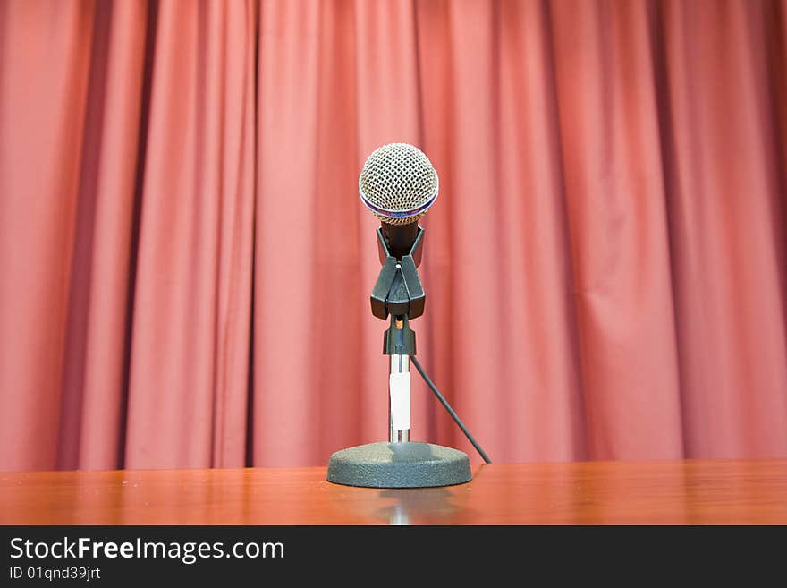 Photograph of microphone in front of a red curtain. Photograph of microphone in front of a red curtain