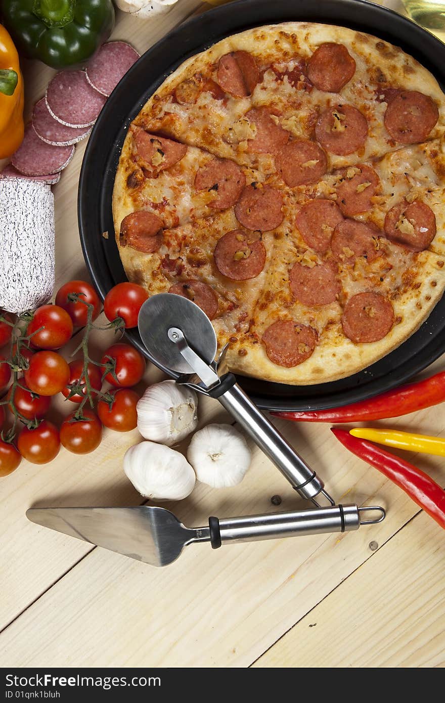 A couple of delicious pizzas, with raw tomatoes, green peppers and salami. A couple of delicious pizzas, with raw tomatoes, green peppers and salami