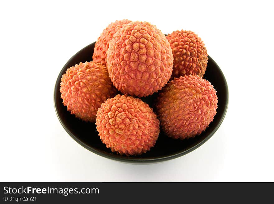 Group of lychee in a black dish with clipping and a white background