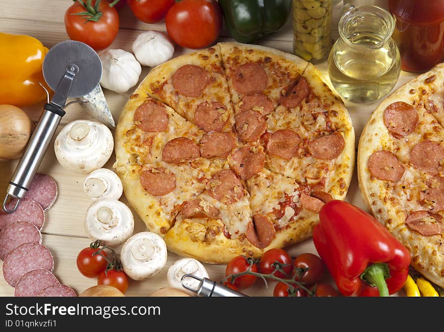 A couple of delicious pizzas, with raw tomatoes, green peppers and salami. A couple of delicious pizzas, with raw tomatoes, green peppers and salami