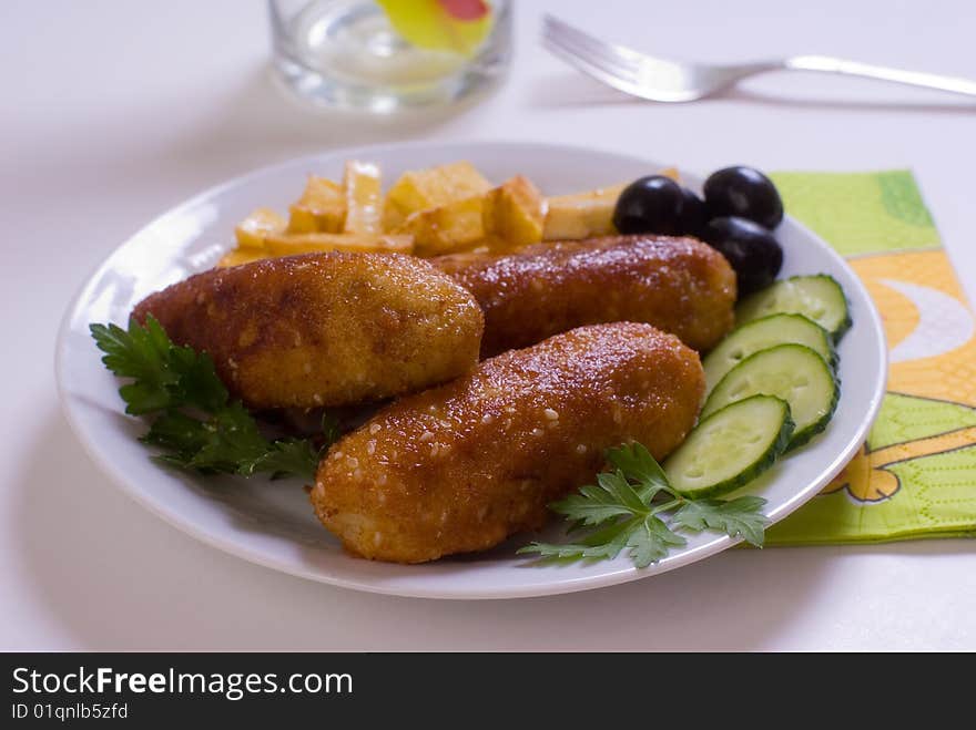 Chicken cutlet with French fries, decorated with green and black olives. Chicken cutlet with French fries, decorated with green and black olives