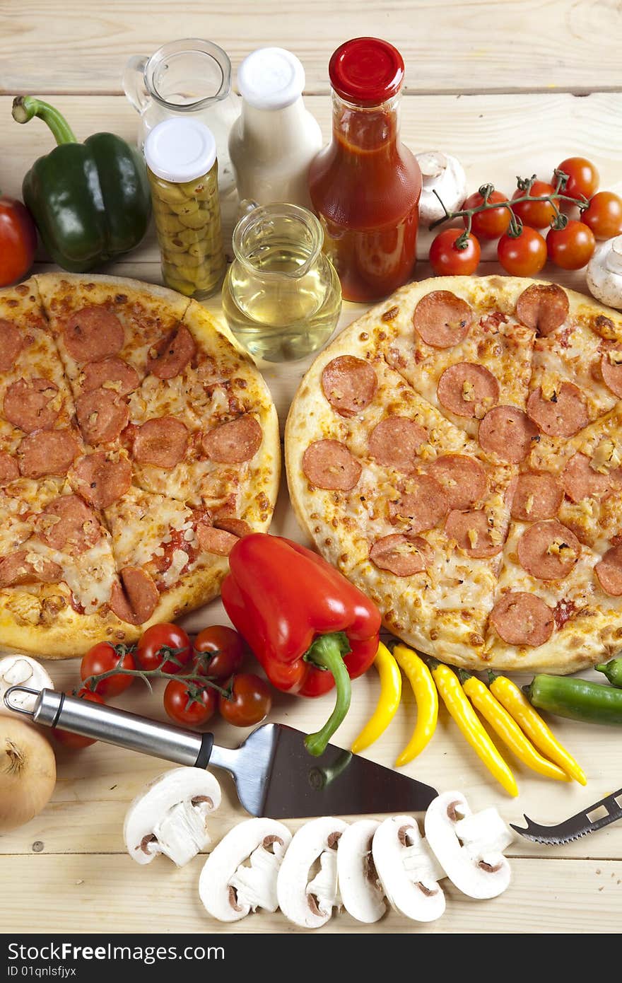 A couple of delicious pizzas, with raw tomatoes, green peppers and salami. A couple of delicious pizzas, with raw tomatoes, green peppers and salami