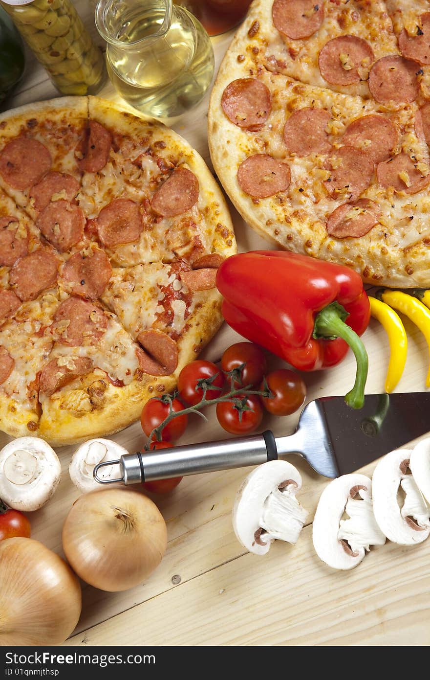 A couple of delicious pizzas, with raw tomatoes, green peppers and salami. A couple of delicious pizzas, with raw tomatoes, green peppers and salami