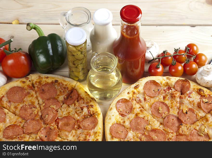 A couple of delicious pizzas, with raw tomatoes, green peppers and salami. A couple of delicious pizzas, with raw tomatoes, green peppers and salami