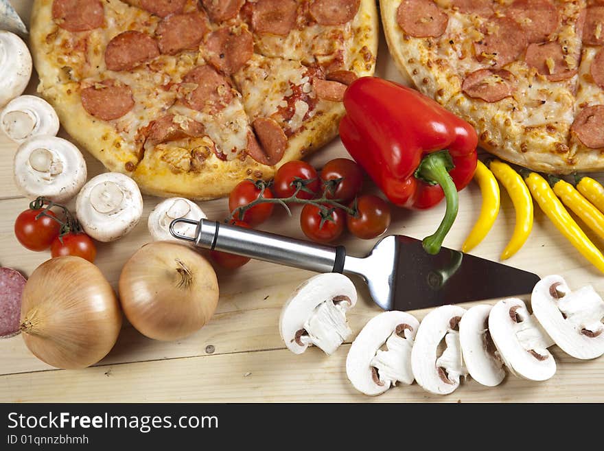 A couple of delicious pizzas, with raw tomatoes, green peppers and salami. A couple of delicious pizzas, with raw tomatoes, green peppers and salami