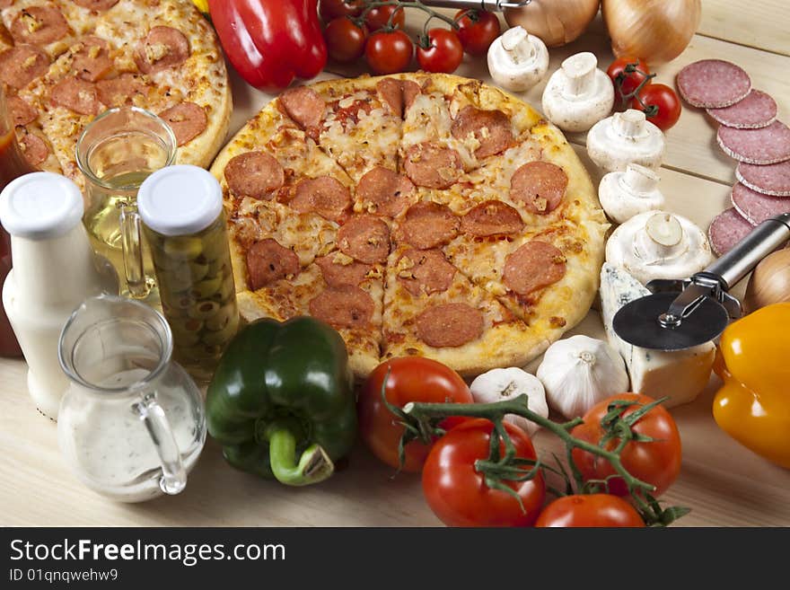 A couple of delicious pizzas, with raw tomatoes, green peppers and salami. A couple of delicious pizzas, with raw tomatoes, green peppers and salami