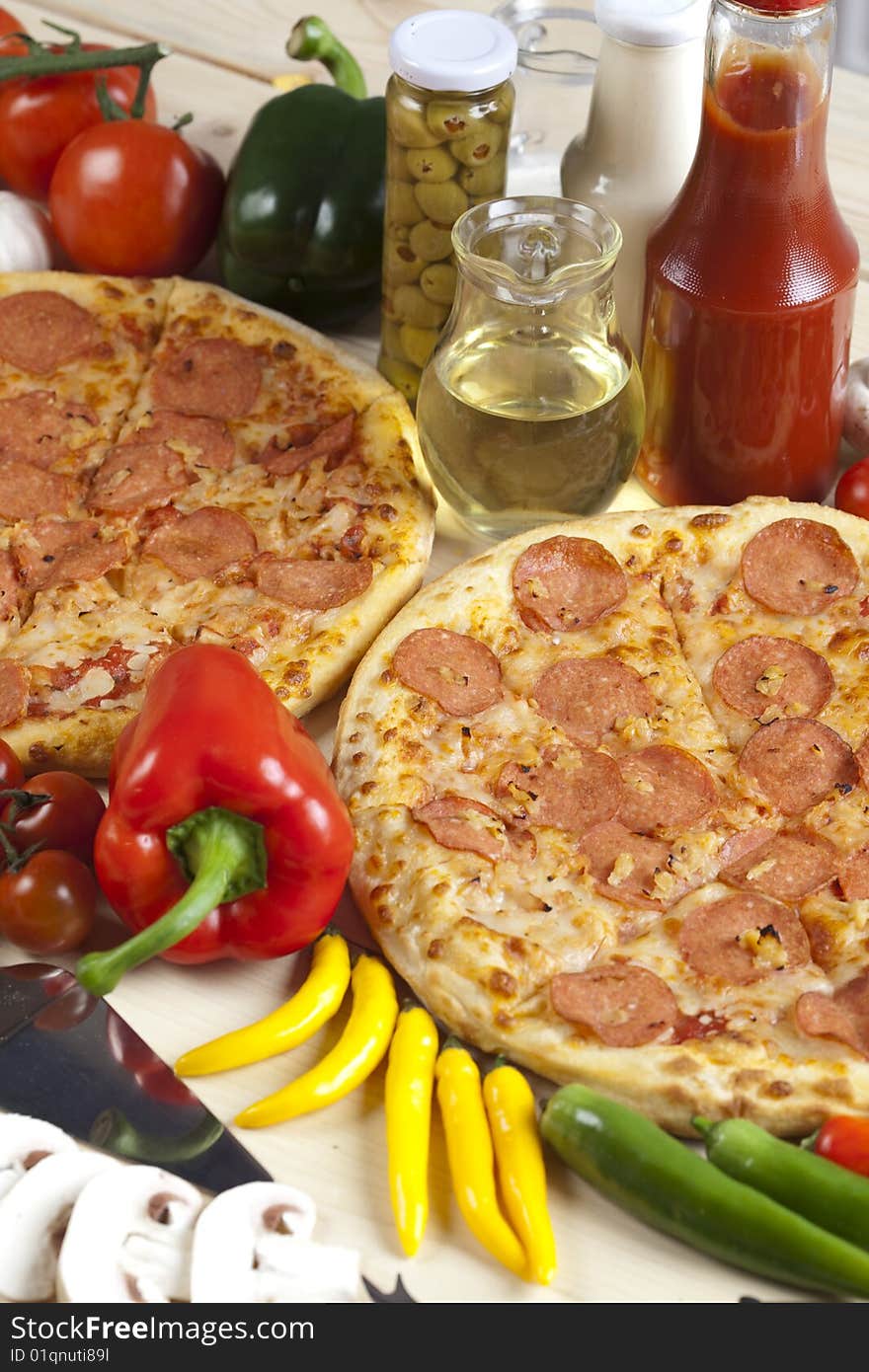 A couple of delicious pizzas, with raw tomatoes, green peppers and salami. A couple of delicious pizzas, with raw tomatoes, green peppers and salami