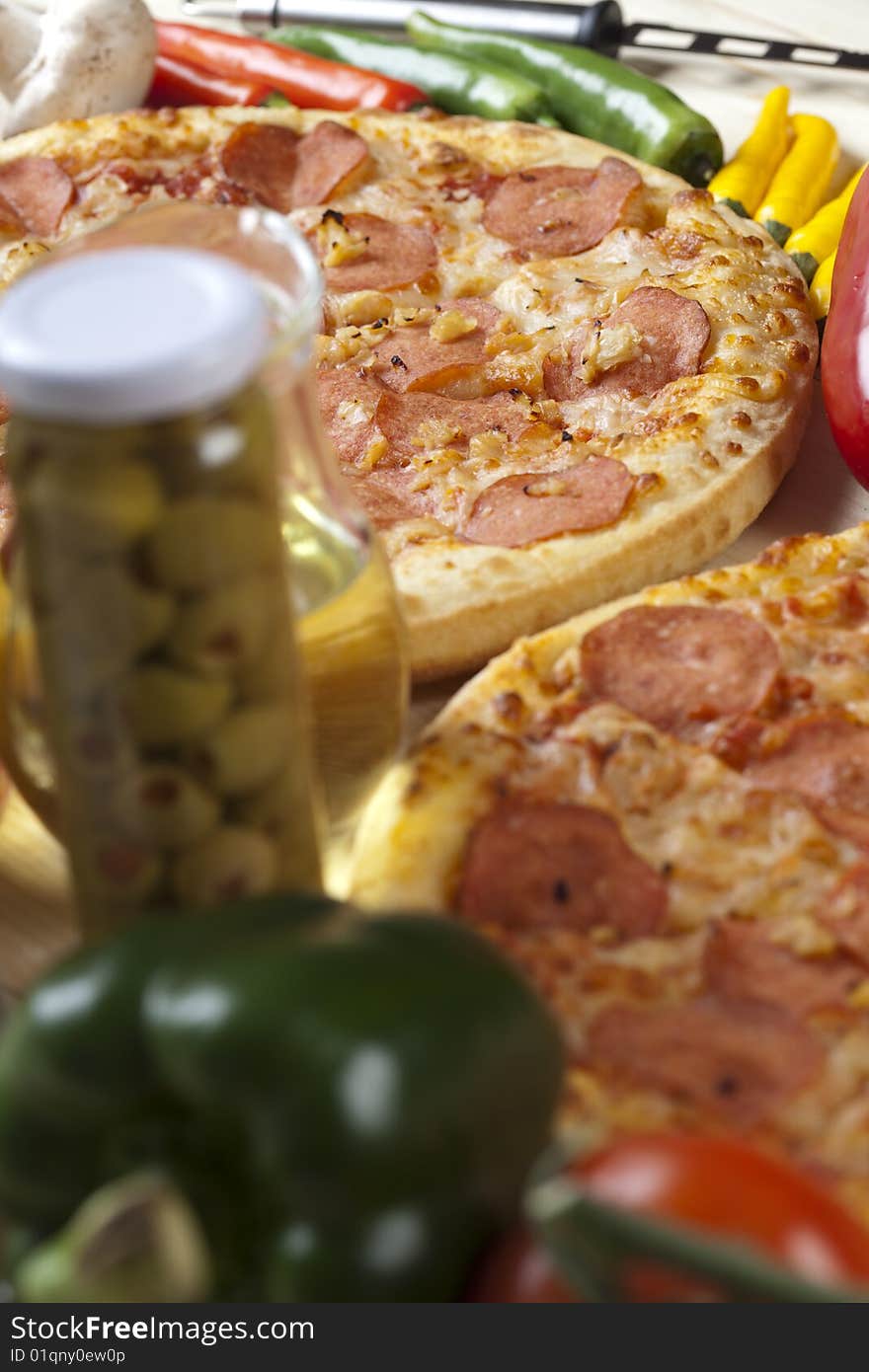 A couple of delicious pizzas, with raw tomatoes, green peppers and salami. A couple of delicious pizzas, with raw tomatoes, green peppers and salami