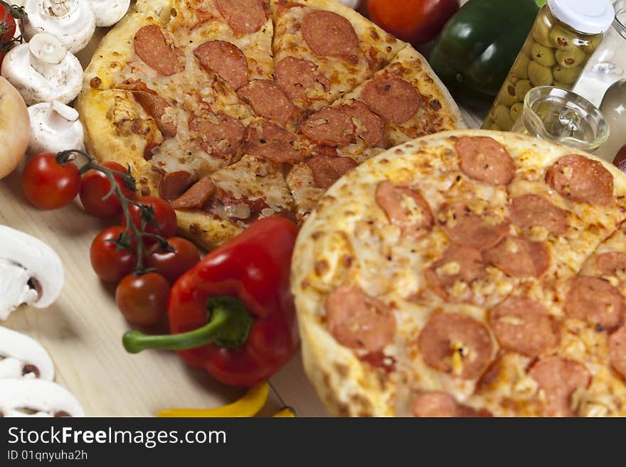 A couple of delicious pizzas, with raw tomatoes, green peppers and salami. A couple of delicious pizzas, with raw tomatoes, green peppers and salami