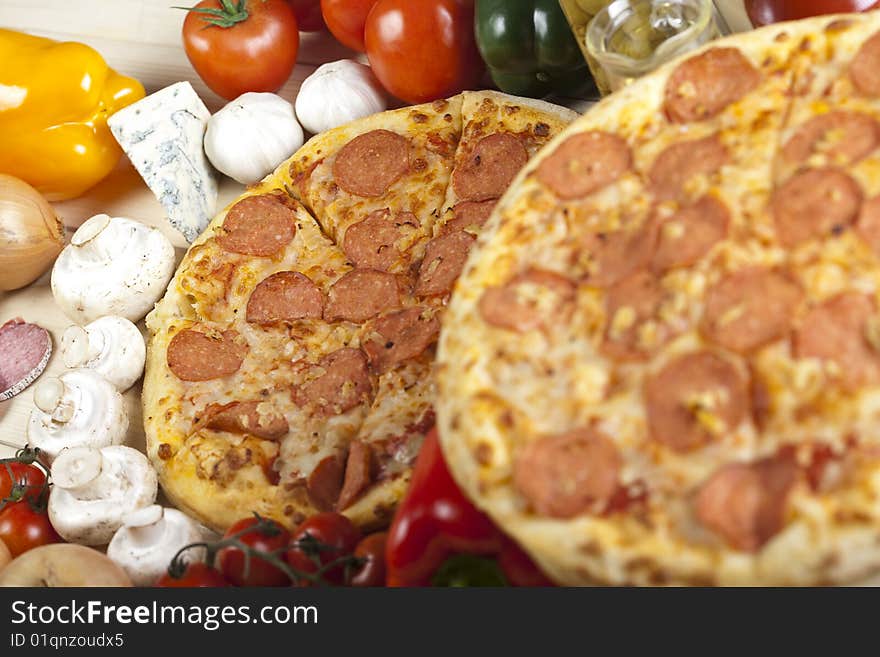 A couple of delicious pizzas, with raw tomatoes, green peppers and salami. A couple of delicious pizzas, with raw tomatoes, green peppers and salami