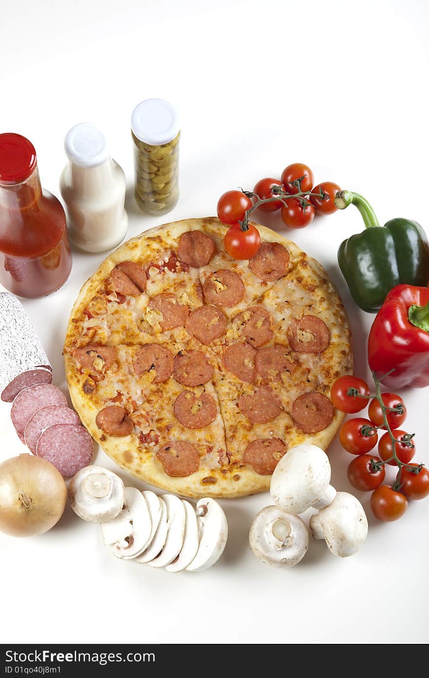 A couple of delicious pizzas, with raw tomatoes, green peppers and salami. A couple of delicious pizzas, with raw tomatoes, green peppers and salami