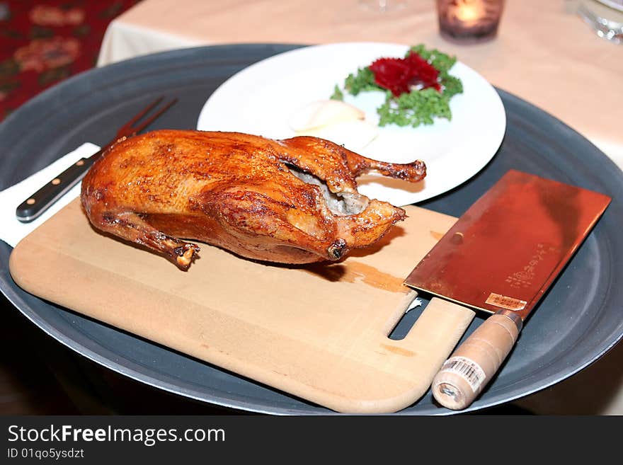 Duck on a wooden cutting board with a sharp cleaver. Duck on a wooden cutting board with a sharp cleaver.