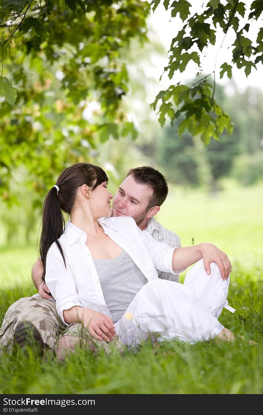 Happy couple together sitting on grass. Happy couple together sitting on grass