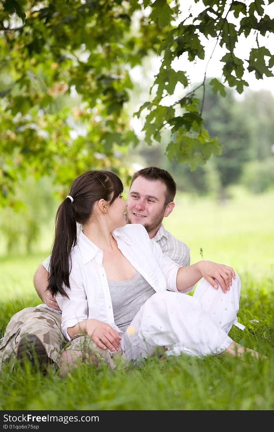 Happy couple together sitting on grass. Happy couple together sitting on grass