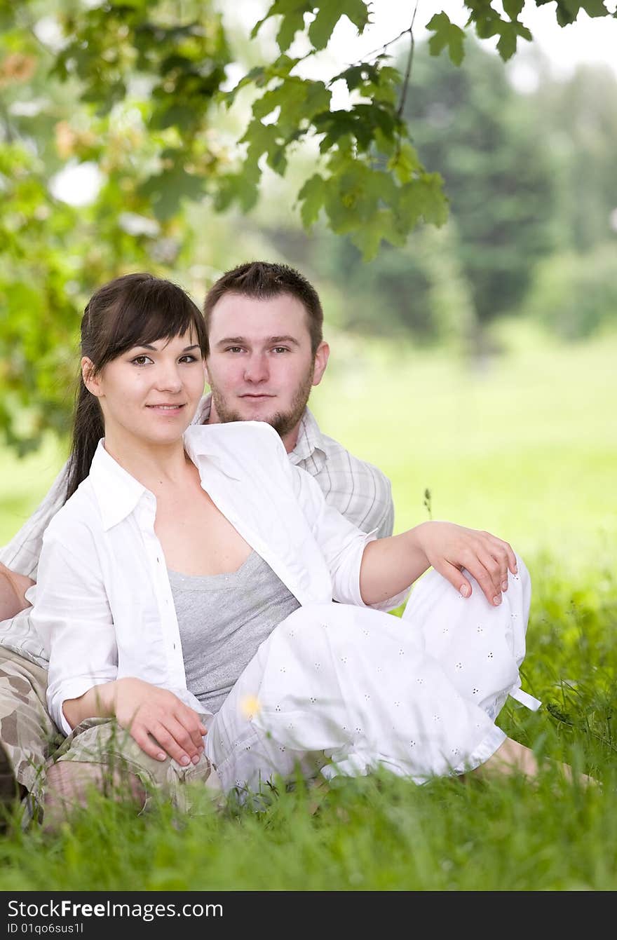 Happy couple together sitting on grass. Happy couple together sitting on grass