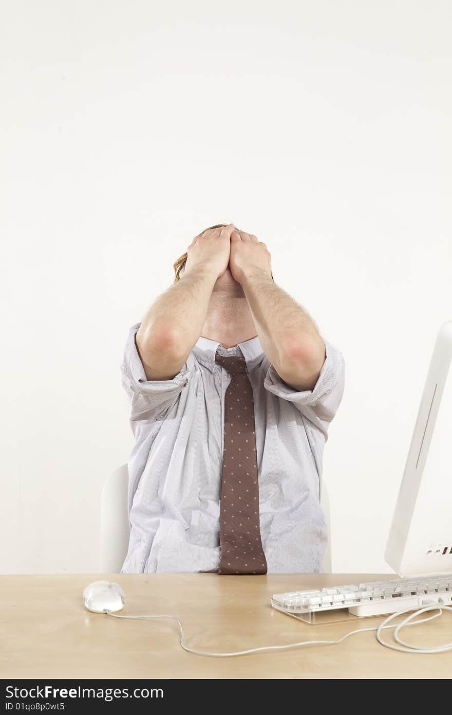 Professional man sitting at desk with face in hands. Professional man sitting at desk with face in hands