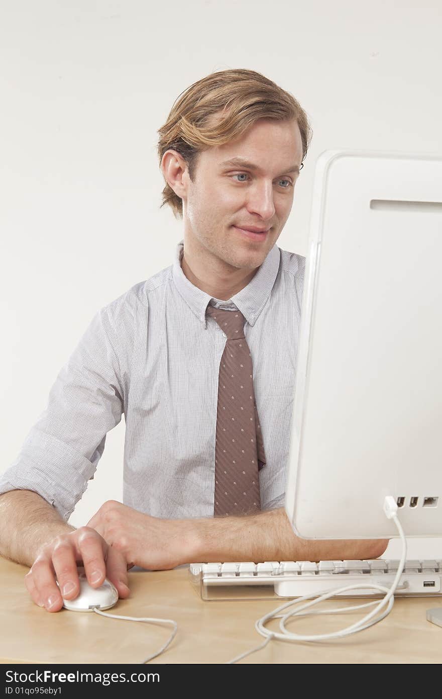 Professional man sitting at computer with pleasant expression. Professional man sitting at computer with pleasant expression