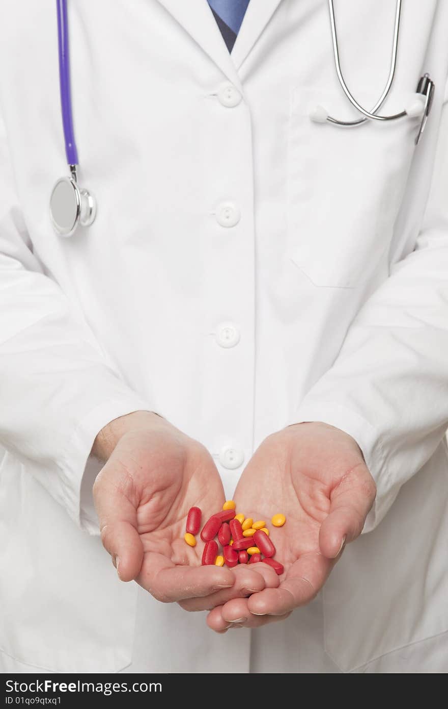 Medical professional holding red and yellow pills. Medical professional holding red and yellow pills