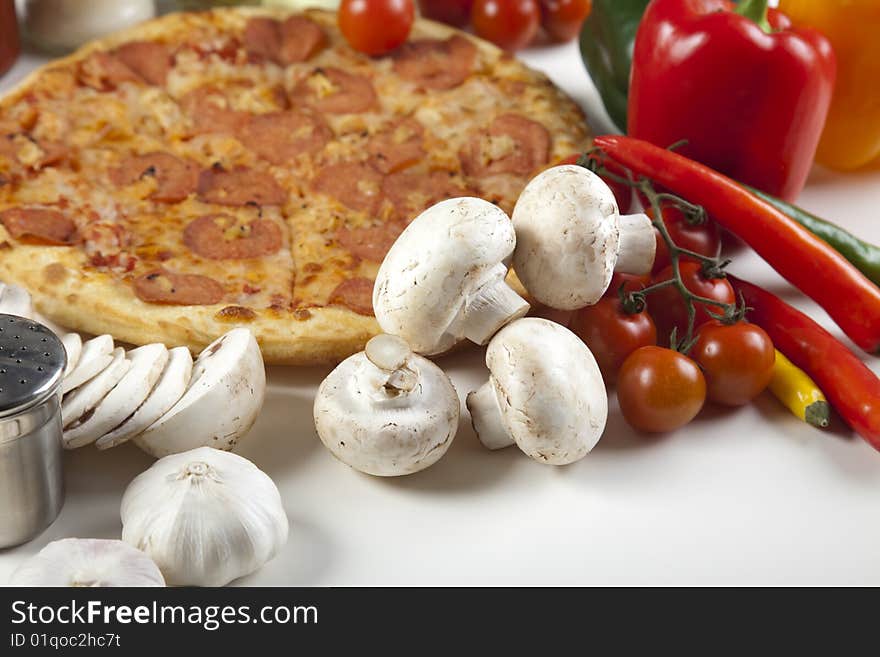 A couple of delicious pizzas, with raw tomatoes, green peppers and salami. A couple of delicious pizzas, with raw tomatoes, green peppers and salami