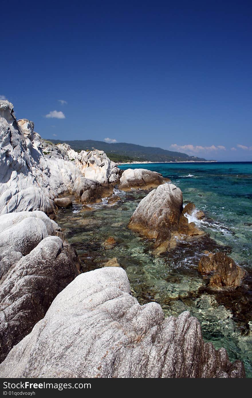 Seashore with rocks and beautiful clear blue water