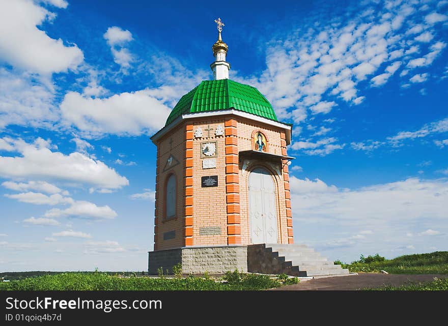 A small chapel on a background of blue sky with clouds