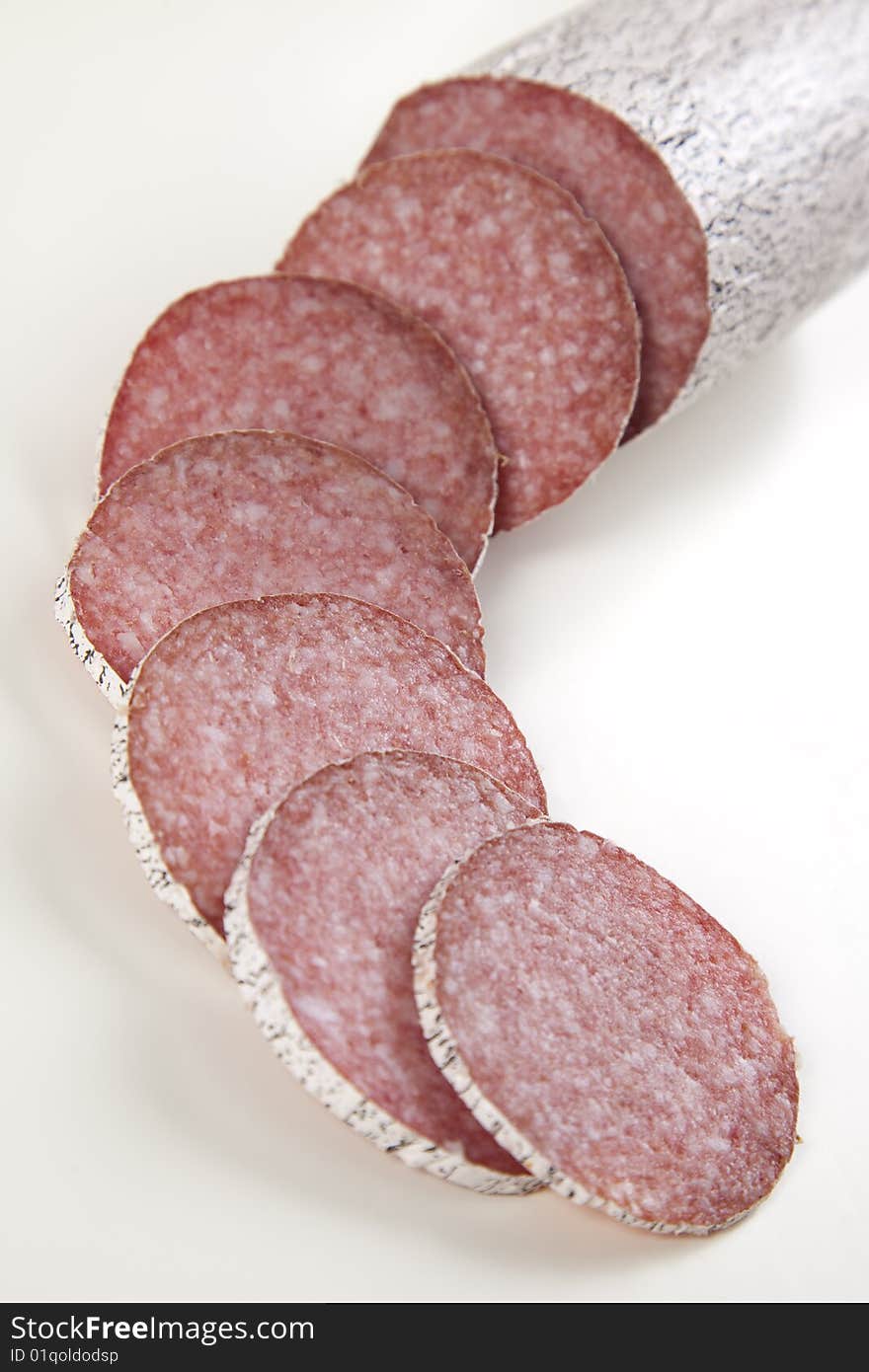 Macro picture of slice of salami isolated on white background