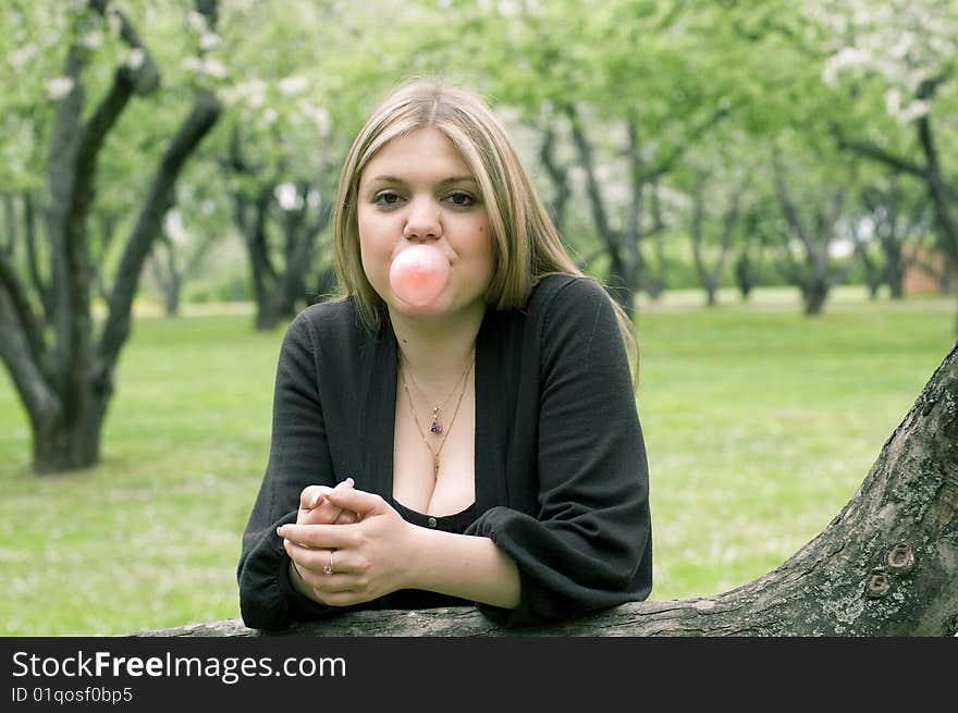 Beauty blond girl blowing bubble gum