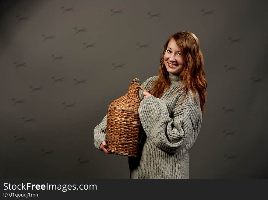 Laughing red haired woman in grey sweater with jar isolated