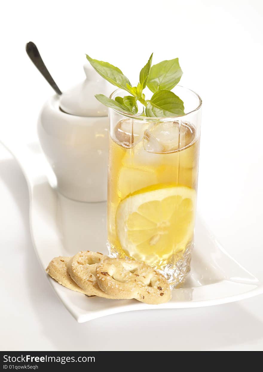 Cold black tea with lemon ice and water drops on the glass surface