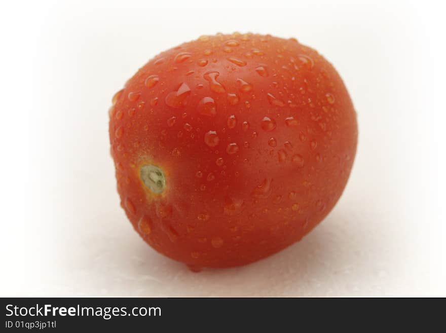 Three red tomatoes with water drops on white background