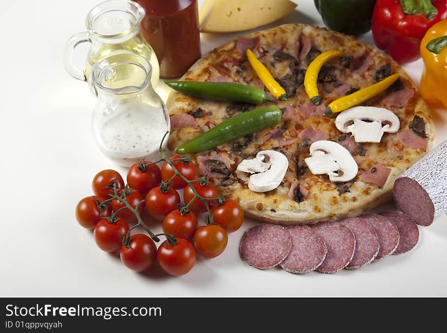 A couple of delicious pizzas, with raw tomatoes, green peppers and mushrooms. A couple of delicious pizzas, with raw tomatoes, green peppers and mushrooms