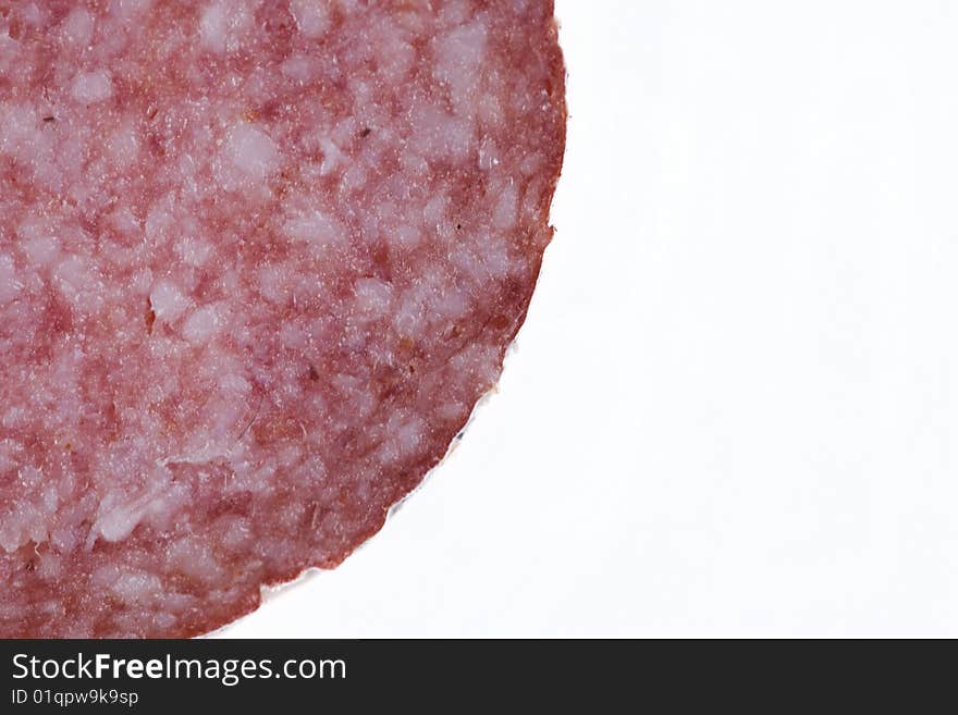 Macro picture of slice of salami isolated on white background