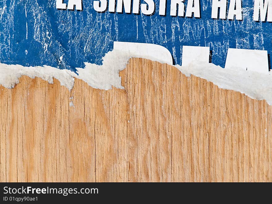 Fragments of torn poster glued on wooden panel. Fragments of torn poster glued on wooden panel