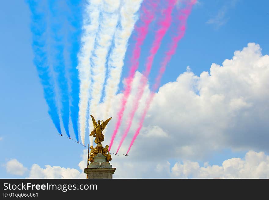 Planes with a multi-coloured smoke fly over the Buckingham palace to time of parade of military-air forces