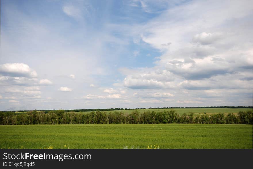 A panoramic view of a meadow and sky. A panoramic view of a meadow and sky