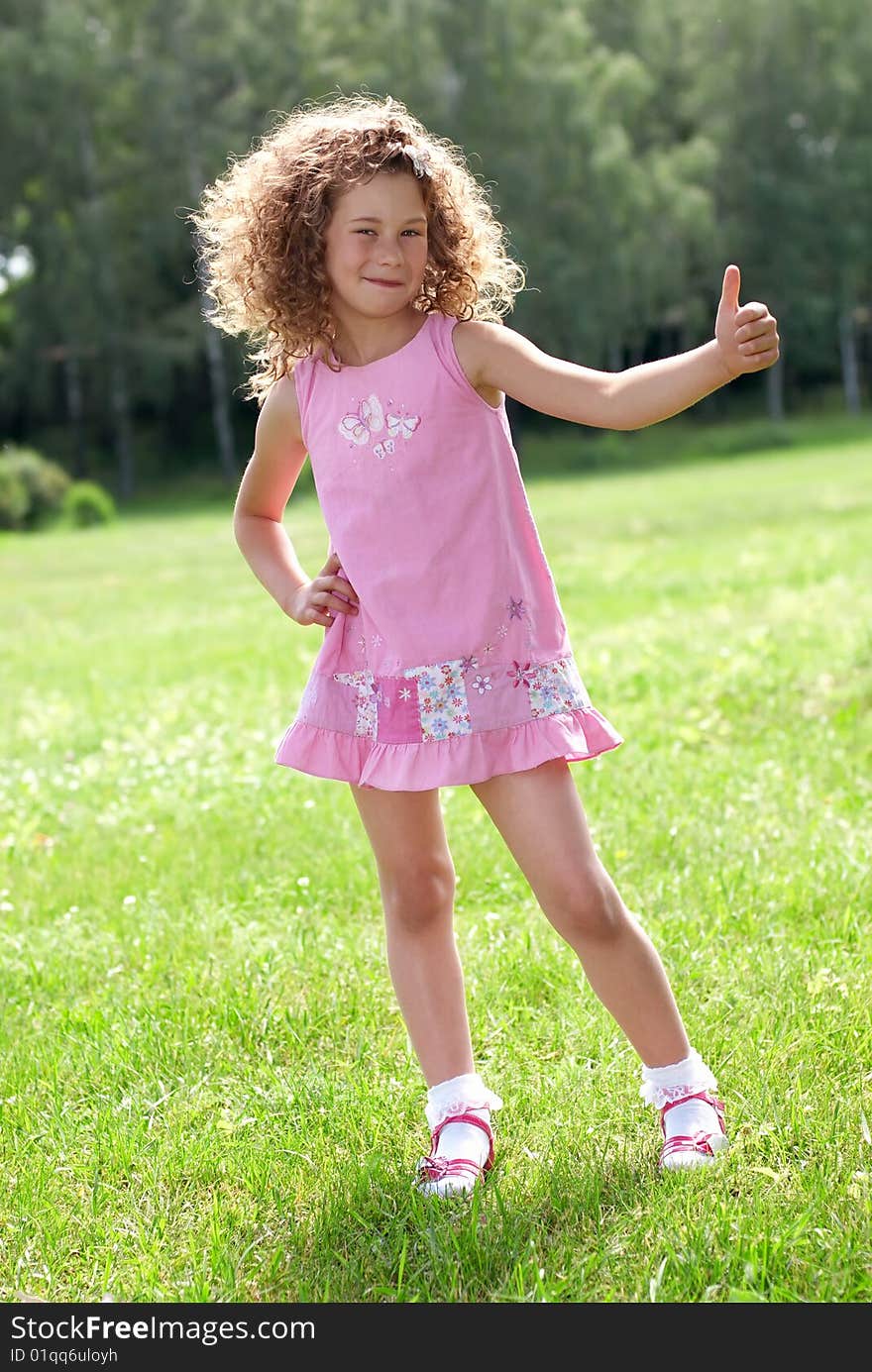 Happy girl showing OK on green nature background. Happy girl showing OK on green nature background