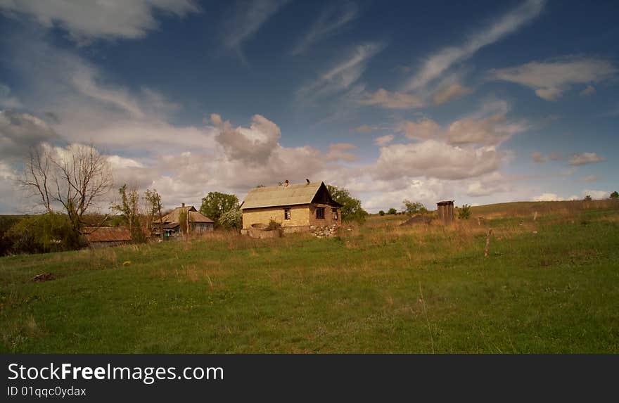 The house in the field in sunset beams. The house in the field in sunset beams