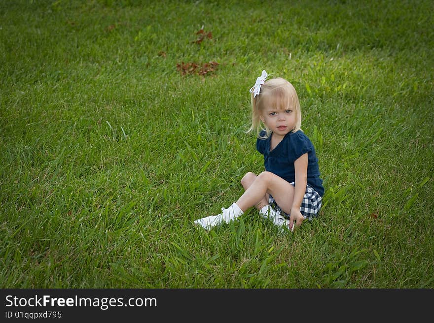 Little girl sitting in grass