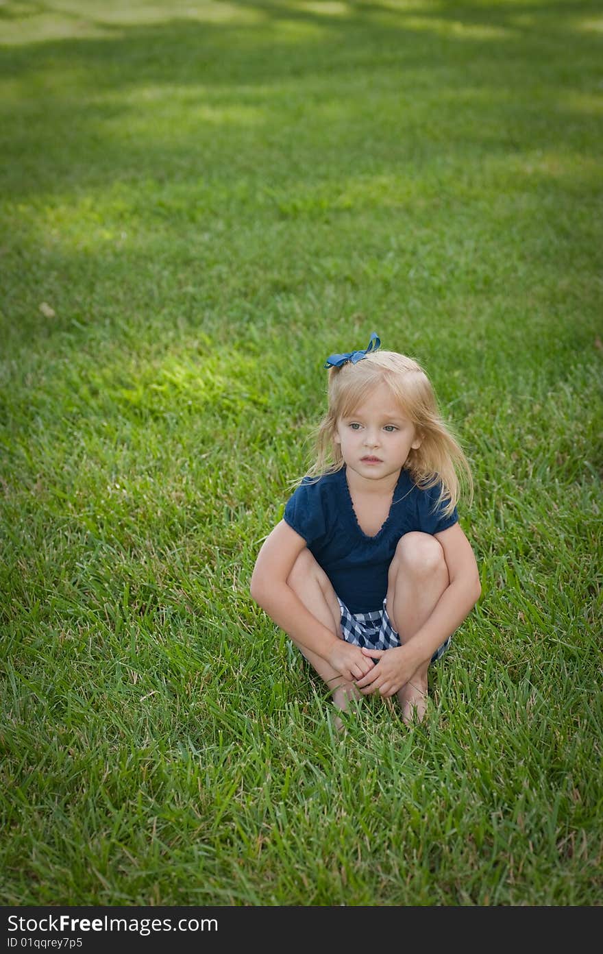 Little girl sitting in grass