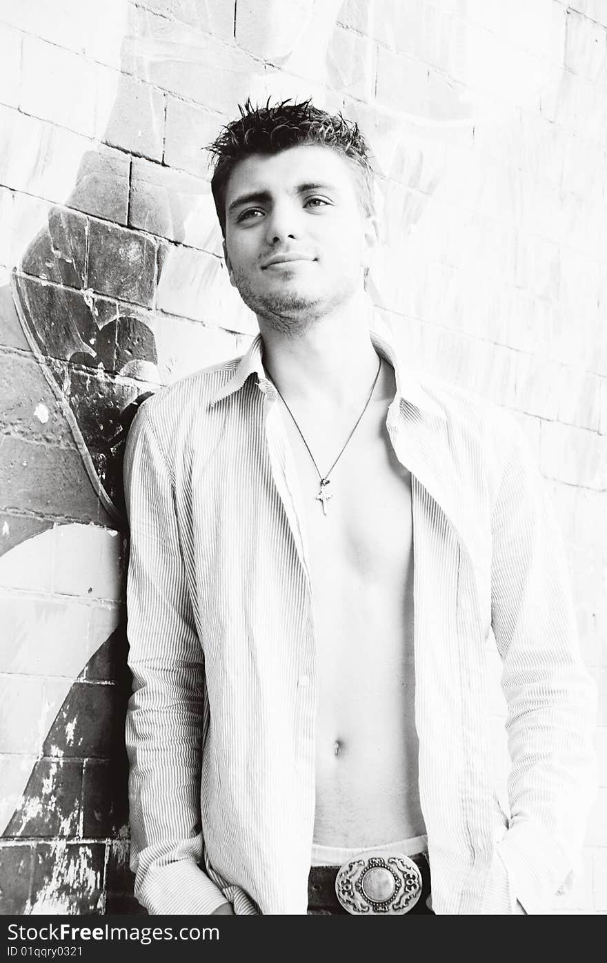 Portrait of handsome young man near the wall in black and white. Portrait of handsome young man near the wall in black and white