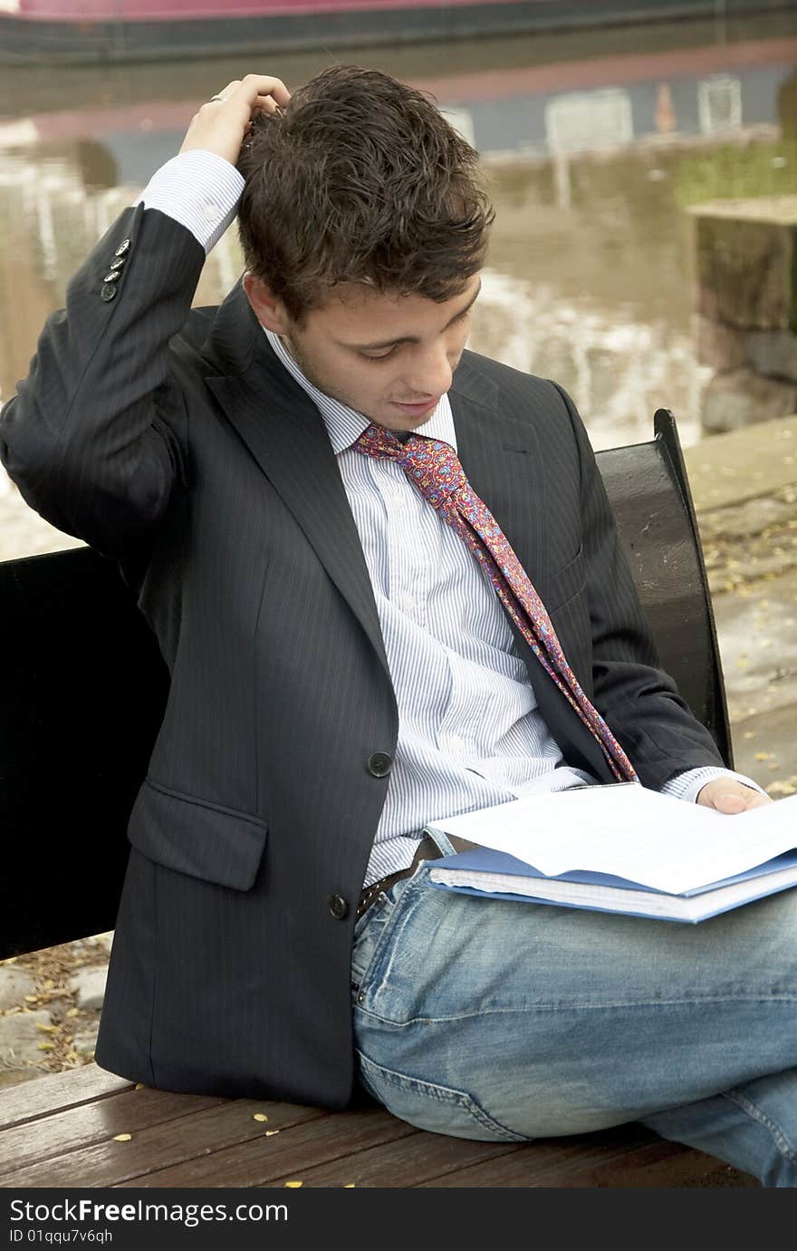 Young handsome man reading a document outside. Young handsome man reading a document outside