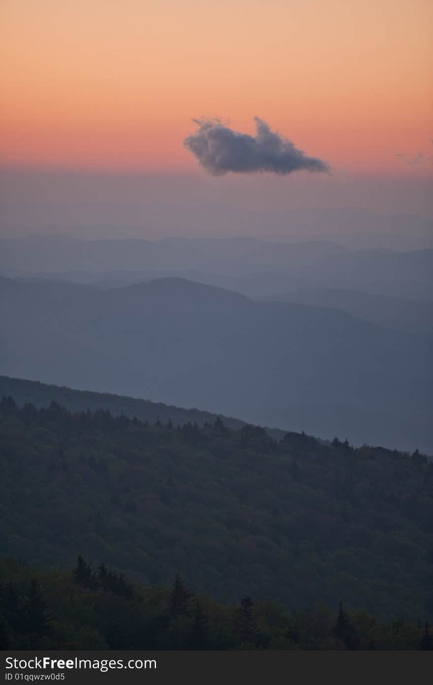 Sunrise blues and pinks with mountain ridges and one cloud hovering in sky at Grandfather Mountain in North Carolina, USA. Sunrise blues and pinks with mountain ridges and one cloud hovering in sky at Grandfather Mountain in North Carolina, USA