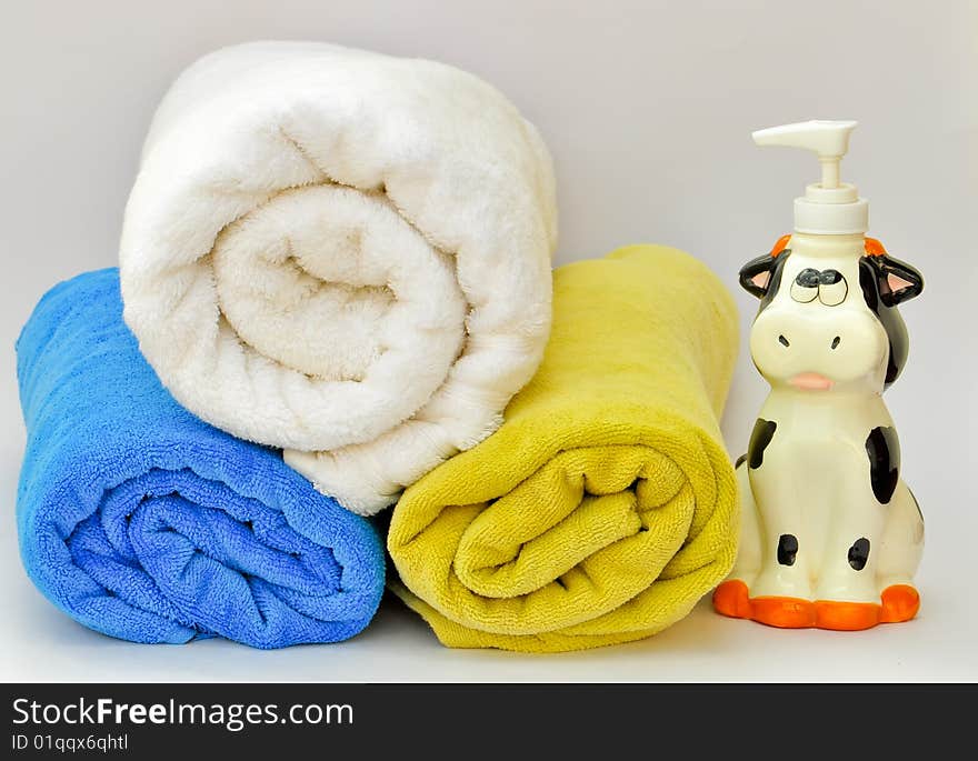 Colorful towels stacked on each other beside a liquid soap dispenser. Colorful towels stacked on each other beside a liquid soap dispenser